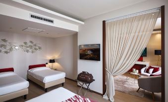 a hotel room with three beds , two of which are twin beds and one is a double bed at Winter Garden Hotel Bergamo Airport