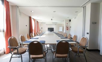 a conference room with a long table and chairs , set up for a meeting or presentation at Belstay Milano Linate