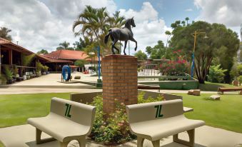 a brick sculpture of a horse is on top of a brick column in a park at Hotel Fazenda Sete Lagos