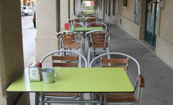 an outdoor dining area with several tables and chairs , some of which are covered in green tablecloths at Hotel El Castillo