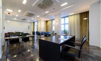 a large conference room with multiple tables and chairs arranged for a meeting or event at Hotel Palace