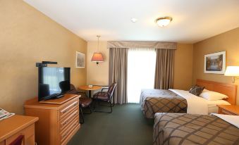 a hotel room with two beds , a desk , and a television , all situated in a well - lit environment at Country Inn Listowel