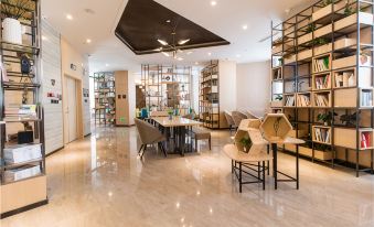 a modern office space with white walls , wooden floors , and large windows , featuring a conference table , chairs , and bookshelves at Atour Hotel at the People's Cinema in Urumqi International Grand Bazaar