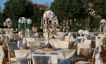 a beautifully decorated outdoor dining area with white tablecloths and chairs , creating a formal atmosphere at Emirtimes Hotel&Spa - Tuzla