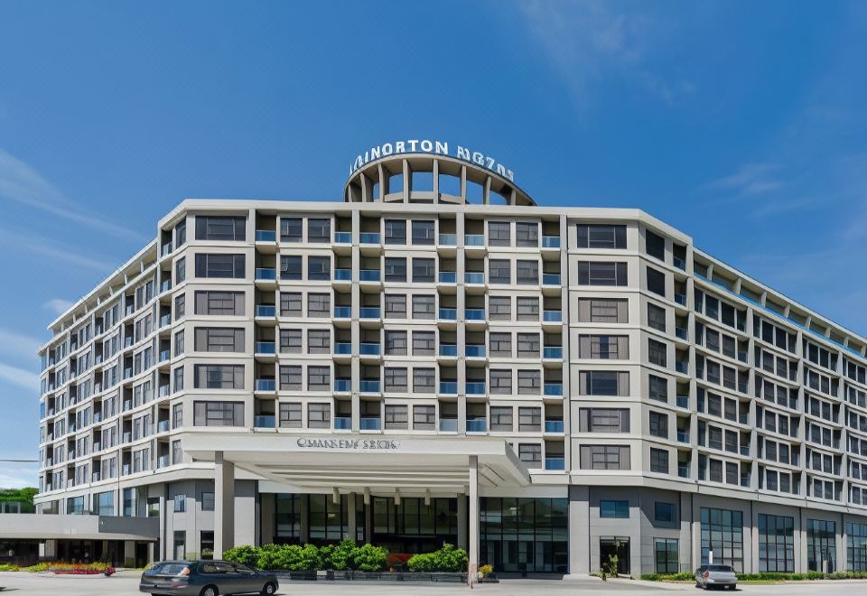 a large hotel building with a parking lot in front of it and cars parked nearby at Livingston Hotel