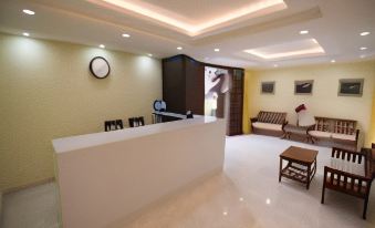 a modern , well - lit waiting area with a white reception desk and multiple chairs arranged around it at Sleeping Buddha