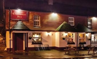"a night view of a building with the sign "" the clonmore inn "" and benches outside" at Crossways Inn