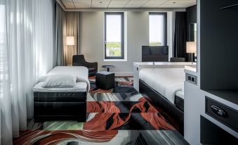 a modern hotel room with two beds , a couch , and a tv , all decorated in white and black colors at Fletcher Wellness-Hotel Leiden