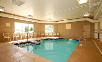 an indoor swimming pool surrounded by a hotel , with people enjoying their time in the pool at Comfort Inn & Suites Saratoga Springs