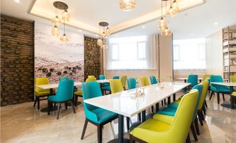 a dining room with multiple tables and chairs arranged for a group of people to enjoy a meal together at Atour Hotel at the People's Cinema in Urumqi International Grand Bazaar