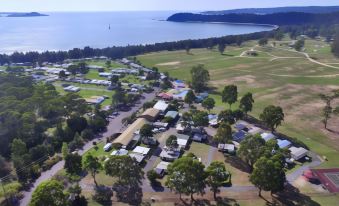 aerial view of a campground near the ocean , with multiple rvs and cabins spread across the landscape at Discovery Parks - Eden