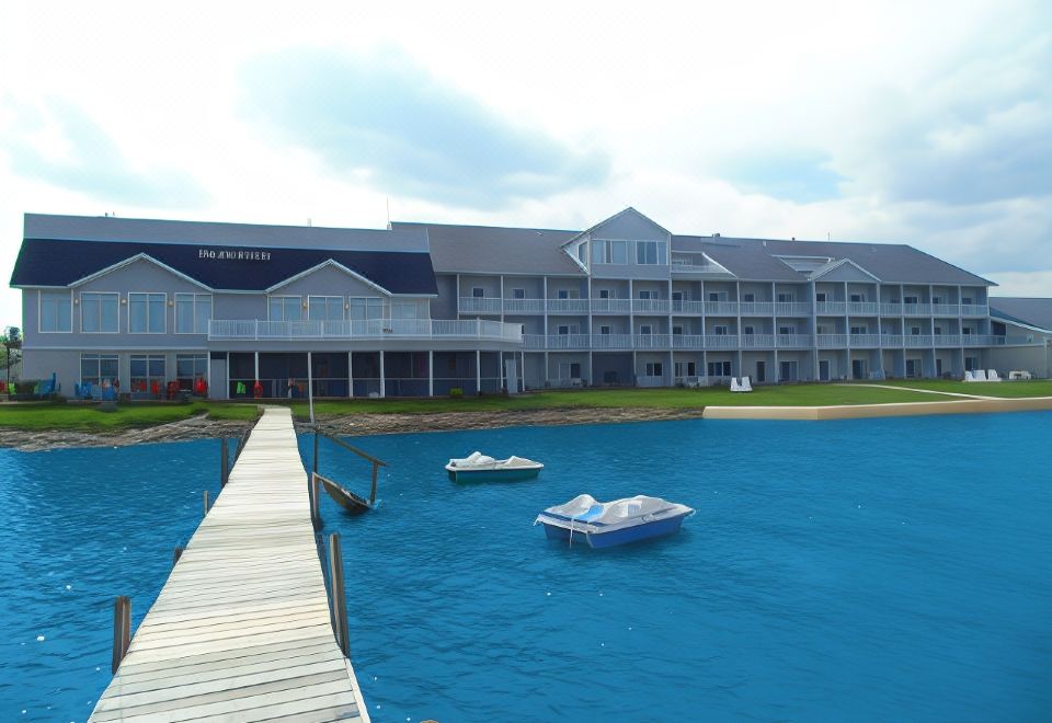 a hotel with a large building and a dock where boats are docked , surrounded by a calm blue sea at Lakeside Resort & Conference Center