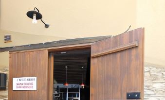 "a small wooden cabin with a sign that says "" cabin house "" is located in front of a building" at River House