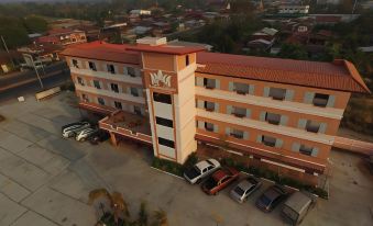 a large building with a parking lot in front of it , surrounded by trees and other buildings at Thatphanom View Hotel