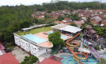 aerial view of a water park with multiple pools , slides , and other attractions in a residential area at Surya Yudha Hotel
