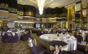 a large , well - decorated banquet hall with multiple round tables and chairs set up for a formal event at Tjokro Hotel Klaten
