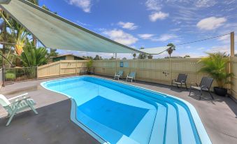 a large blue swimming pool surrounded by a patio , with a house in the background at Hi-Way Motel Grafton - Contactless