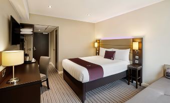 a large bed with a white and maroon blanket is in the middle of a room at Premier Inn Lichfield North East (A38)