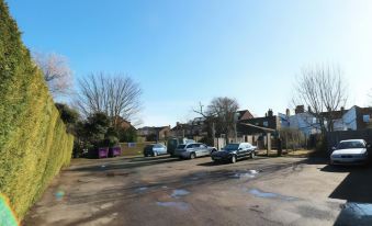 a parking lot with several cars parked , including a blue car in the foreground and another green car in the background at The Pheasant Inn