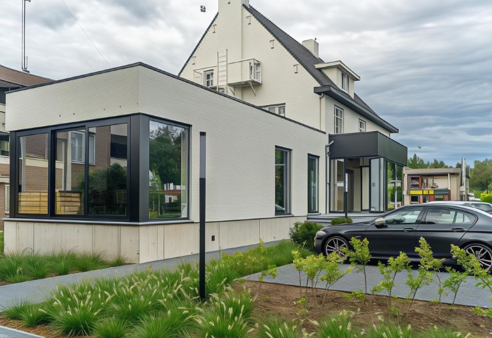 a modern house with a car parked in front of it and a garden area at Hotel Huron