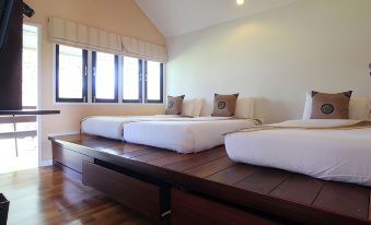 a room with three beds , one on the left , one in the middle , and one on the right at Baan Suan Nuan Ta