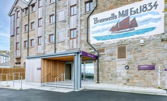"the exterior of a building with wooden beams and large windows , featuring a sign advertising "" branwell 's mill eagle "" and a sailboat" at Premier Inn Penzance