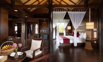 a luxurious hotel room with a large bed , wooden furniture , and an open door leading to a balcony at Mane Hariharalaya