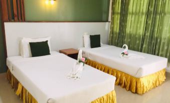 a hotel room with two beds , one on the left and one on the right at Suanpa Resort