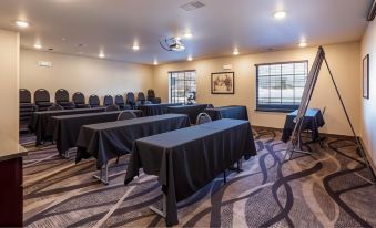 a conference room with black tables and chairs arranged in rows , ready for a meeting at Cobblestone Inn & Suites - Brookville