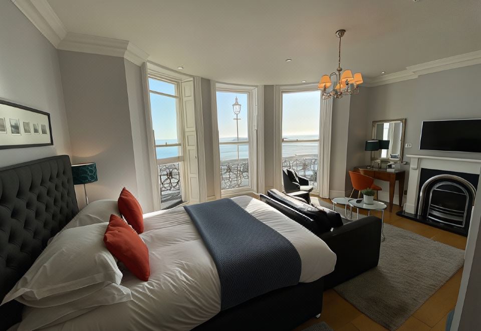 a bedroom with a large bed and a view of the city through two windows at A Room with A View
