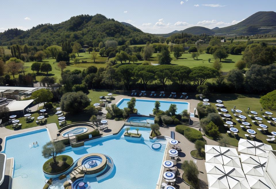 an aerial view of a resort with multiple swimming pools and golf courses in the background at Hotel Majestic
