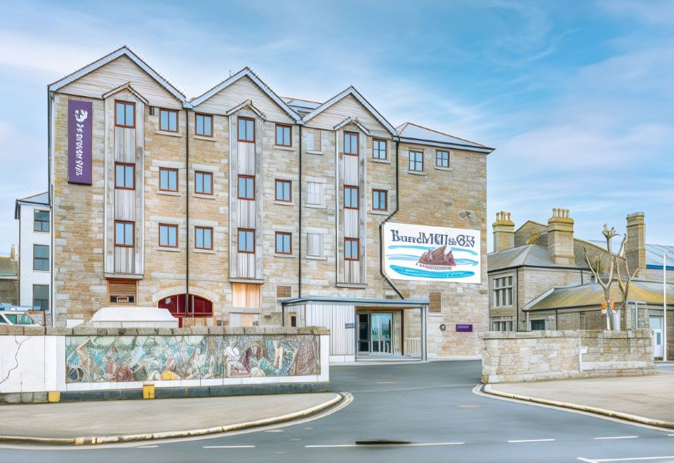 "a large building with a sign that says "" travelodge "" is situated on a street corner" at Premier Inn Penzance
