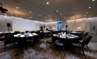 a large dining room with multiple tables and chairs set up for a formal event at voco MANCHESTER - CITY CENTRE