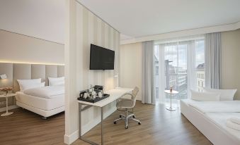 a modern hotel room with a white desk , bed , and window , along with a bed , coffee maker , and kitchenette at NH Leipzig Zentrum