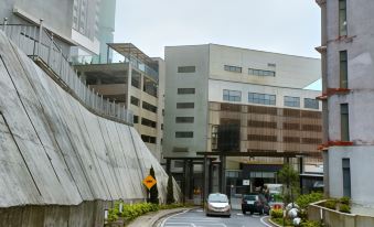 The view from the street shows an apartment complex with cars parked on both sides and buildings at MagTree Genting Highlands