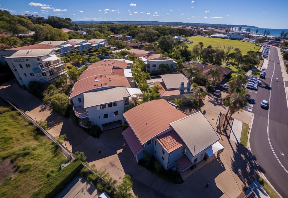 aerial view of a residential area with multiple houses and trees , under a clear blue sky at Lennox Beach Resort
