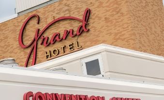 "a grand hotel building with a red sign that reads "" convention center "" prominently displayed on the side of the building" at Grand Hotel