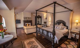 a luxurious bedroom with a large four - poster bed and a fireplace , creating a warm and inviting atmosphere at The Himalayan