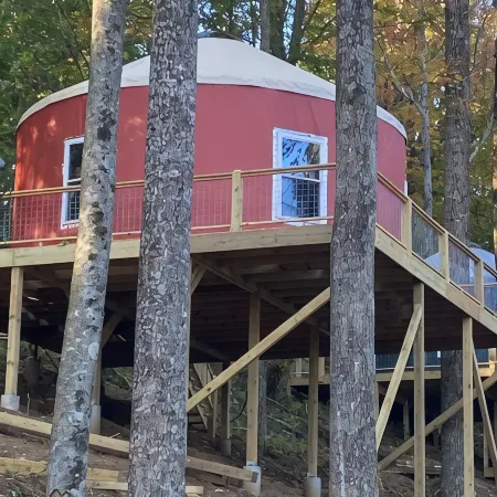 Elevated eclectic yurt with wrap-around porch, hot tub, and mountain view!