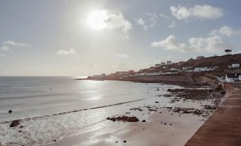 a serene beach scene with the sun shining brightly over the ocean , creating a picturesque view at The Bay Hotel