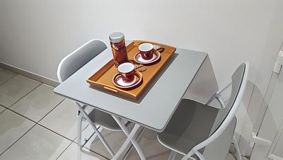 a table with a tray holding two cups , a bottle , and a can is set up in a room at Vichy