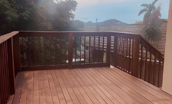 a wooden deck with a railing overlooks a scenic view of trees and mountains under a clear sky at Sweet Home Alibama