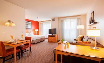 a hotel room with a king - sized bed , a flat - screen tv , a desk , and a chair at Residence Inn Phoenix Goodyear