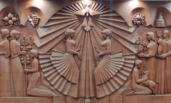 a decorative wall sculpture with three women dancing in front of a sunburst , creating a unique and captivating scene at Richmind Hotel