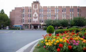 a large building with a flower garden in front and a flower bed in front at Richmind Hotel