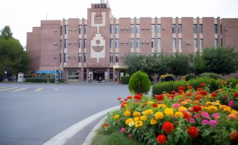 a building with a large flower bed in front of it , creating a pleasant and inviting atmosphere at Richmind Hotel