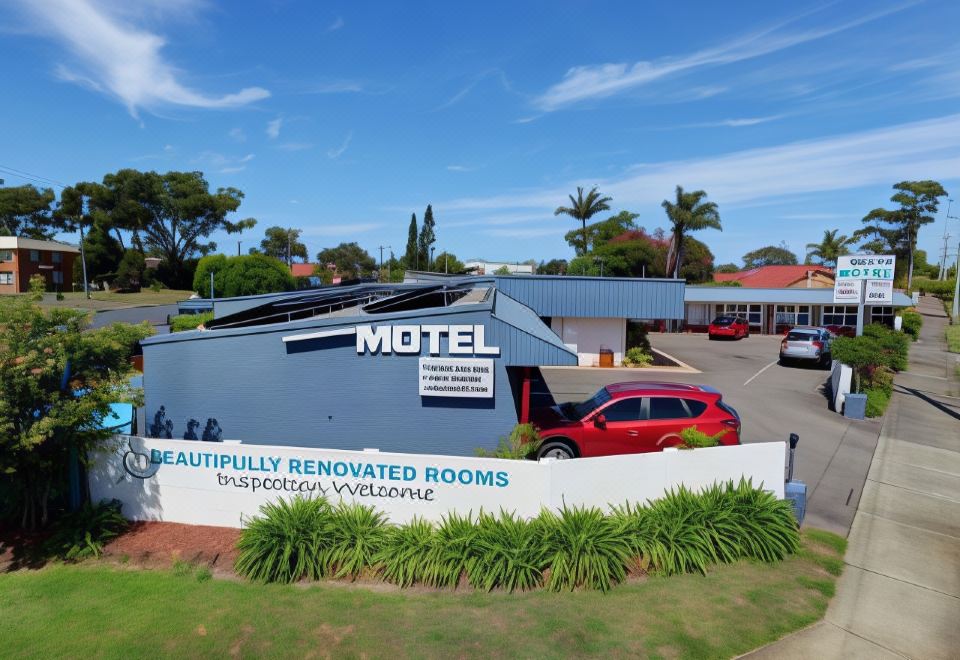 "a large building with a sign that says "" dreamfully renovated rooms "" and a red car parked in front of it" at Bali Hi Motel