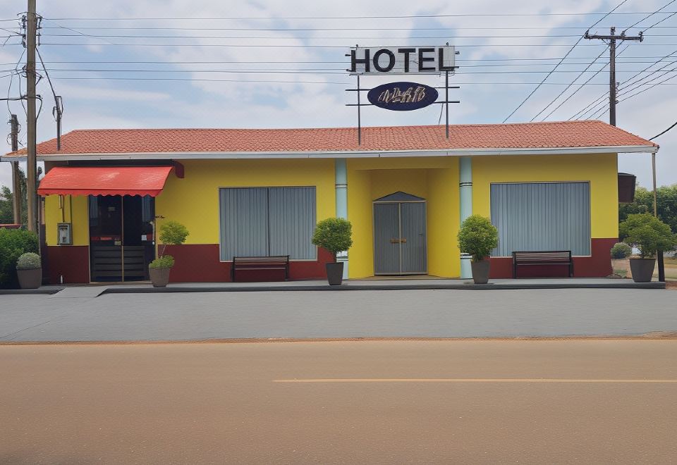 "a yellow building with a sign that says "" hotel "" on it , and several potted plants in front of it" at Hotel Greenville