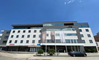 a modern building with multiple flags hanging from the side , indicating the presence of a company at Hotel Leone