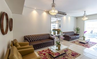 a living room with two brown leather couches , a coffee table , and a rug on the floor at Hotel Nacional Inn Araçatuba